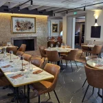 Salle principale de l’Auberge du Kochersberg à Landersheim, tables dressées, ambiance élégante et chaleureuse.